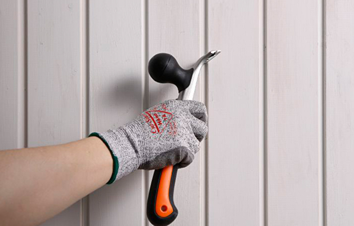 Verwijder losse schilfers, verflagen en bros hout met een schraper en schuurmachine